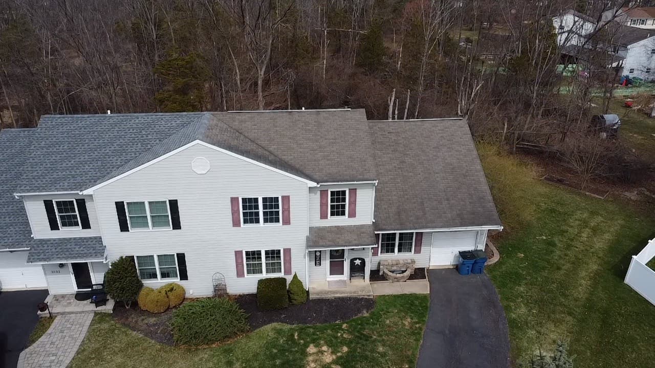 Aerial view of a completed asphalt shingle roof replacement by E&K Contracting on a two-story colonial home in southeastern Pennsylvania