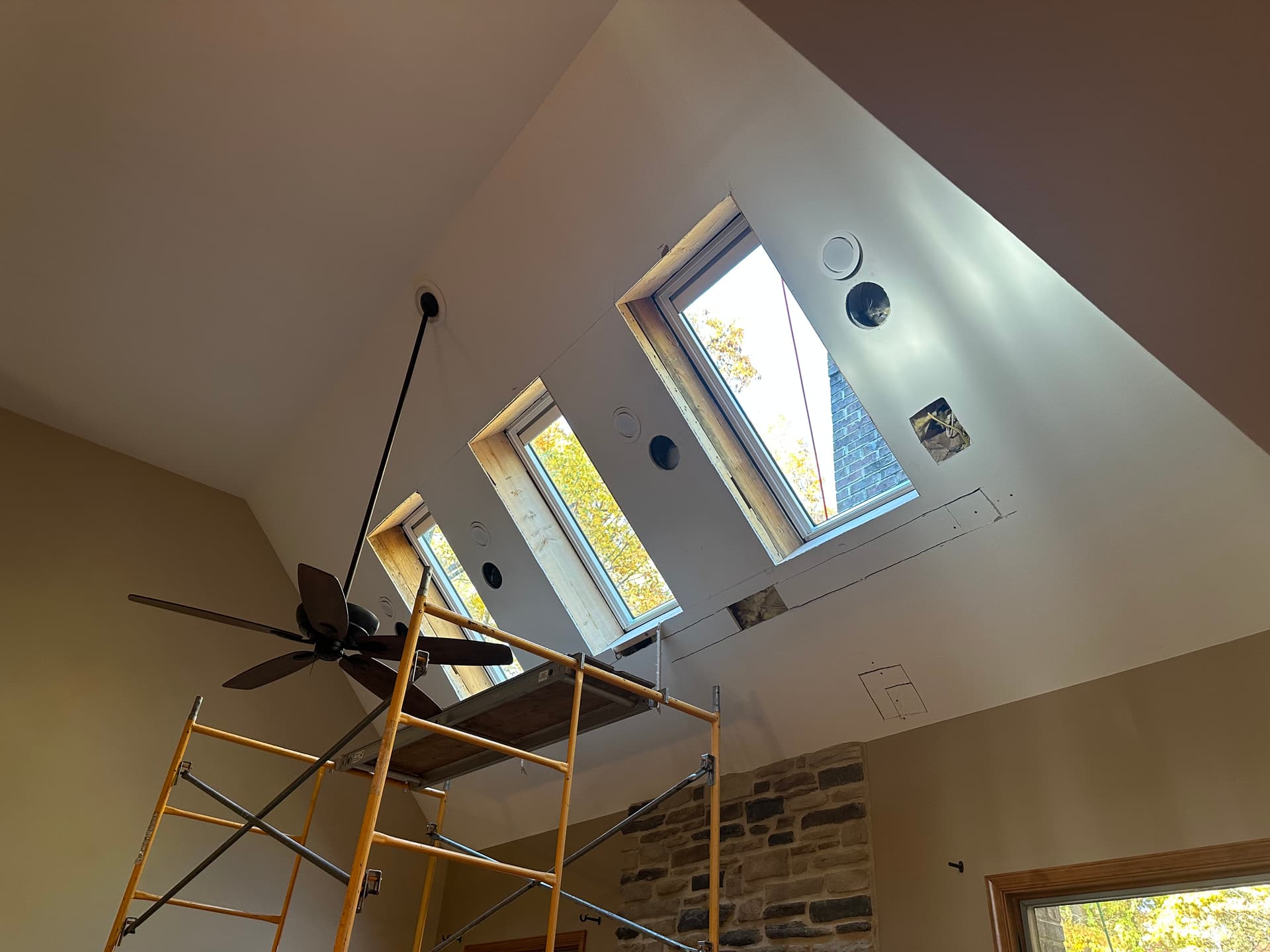 Interior view of three skylights installed in a vaulted ceiling, filling the room with natural light