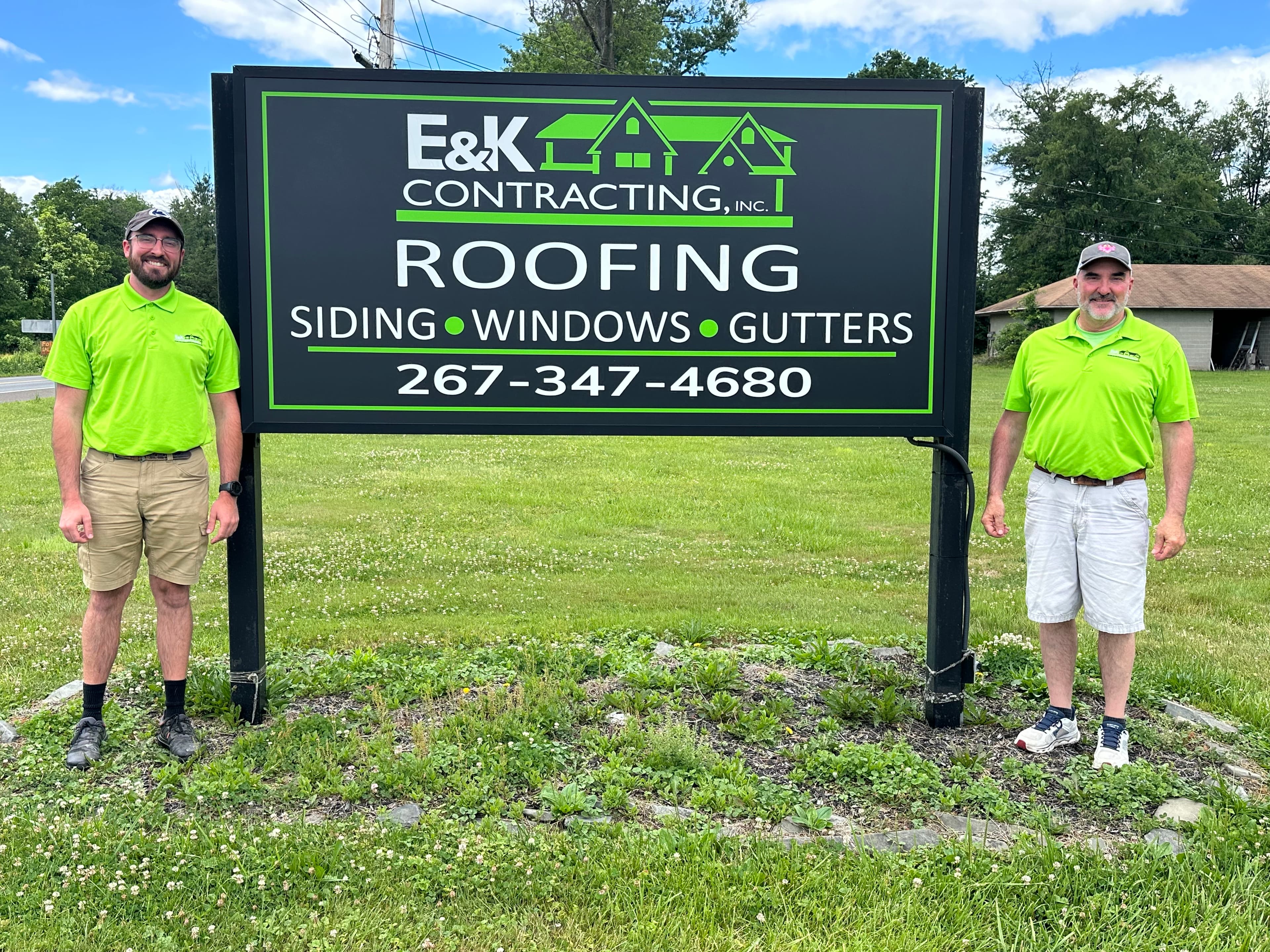 E&K Contracting team at the company sign.
