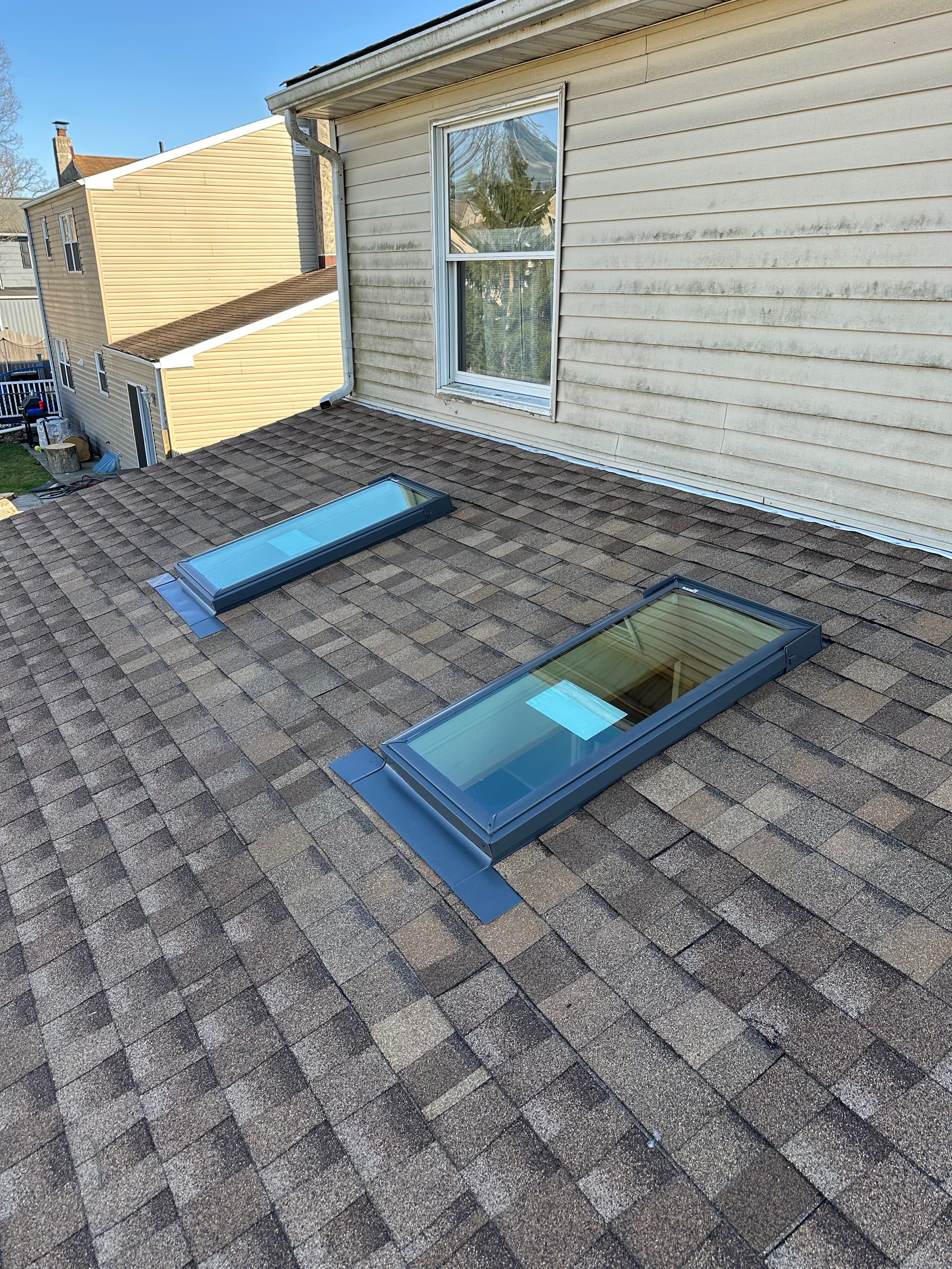 Two completed Velux skylights flashed into an architectural shingle roof on a residential home
